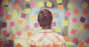 Woman overlooks sticky notes and lessons from the week