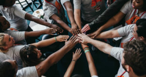 A circle of diverse hands joins together