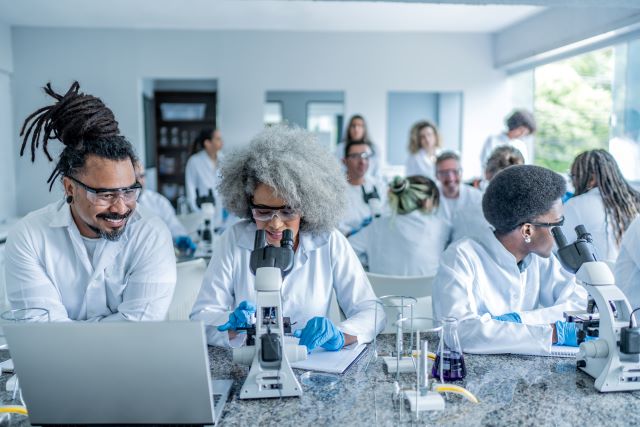 Students and instructors working in a lab together