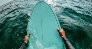 Person holding onto their surfboard in the ocean