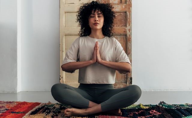 Person meditating in front of scratched up door