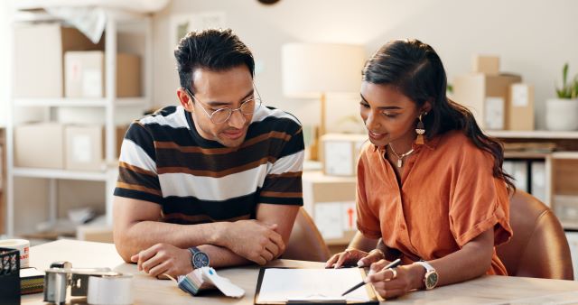 Two people sitting and talking to one another at table having discussion