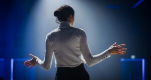 Woman on stage with lights on her while presenting