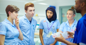 A group of four nursing students are meeting with an instructor in the field.