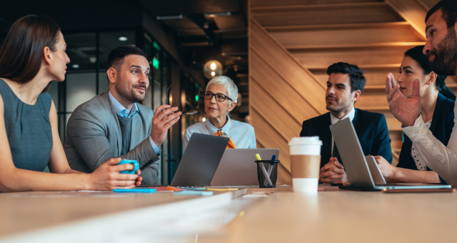 A group of business leaders sitting around a table having a meeting.