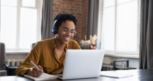 College student wearing glasses and headphones participating in an online class