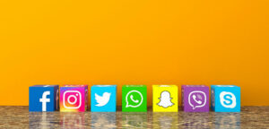 On a bright yellow background, logos for Facebook, Instagram, Twitter, What'sApp, Snapchat, Skype