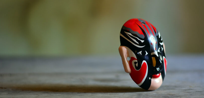 Red, black and white mask on a wooden table