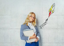 Studio shot of a glad female student in glasses with the books - get started with your studies