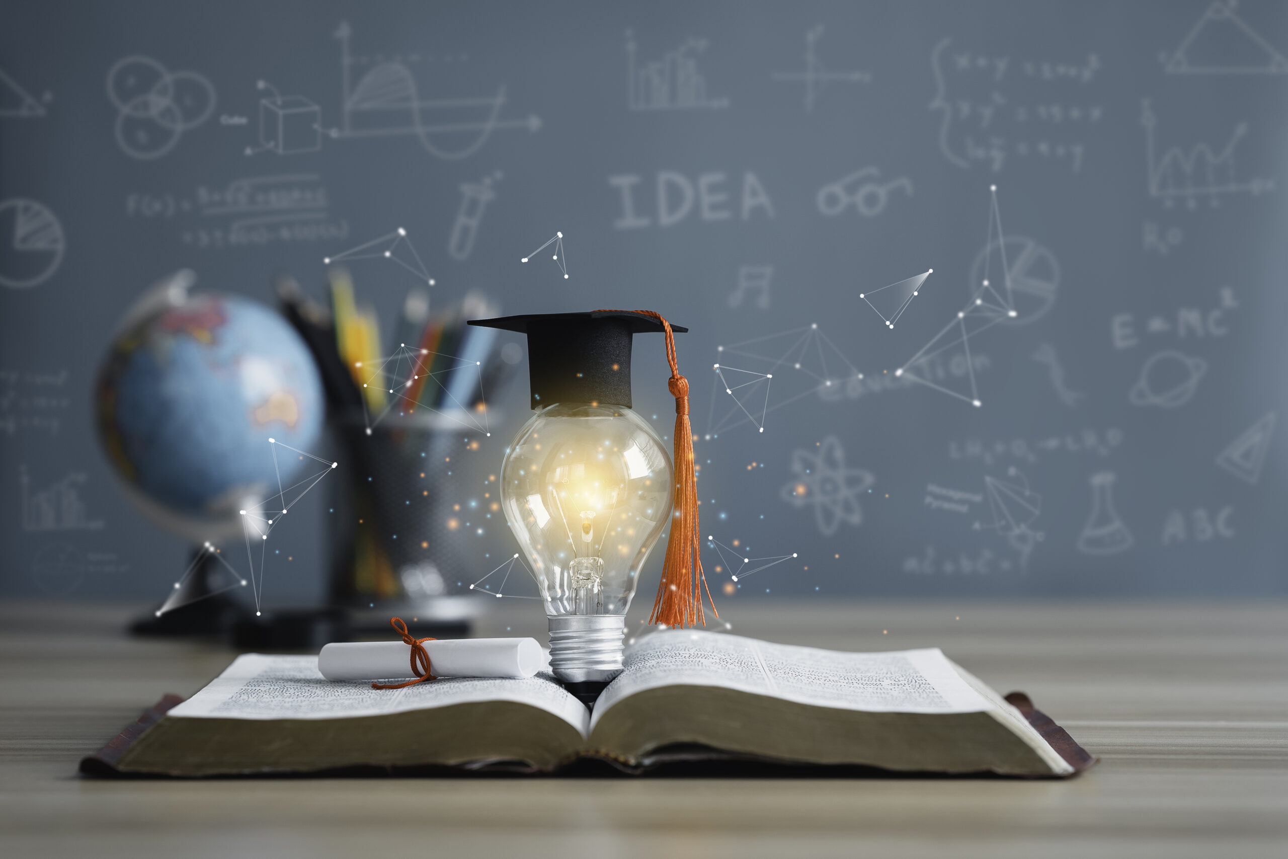 Graduation cap with a lightbulb on the book and globe in the classroom. Education learning concepts in school or university. Idea knowledge of innovative technology, science, and mathematics.