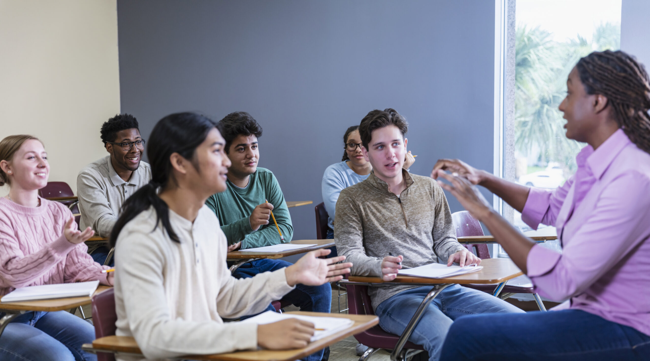 An African American teacher leading a class with a diverse classrooms of students. intercultural communication.