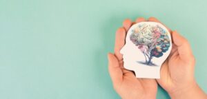 Hands holding silhouette of head with colorful plant growing. health and wellness. self-care.