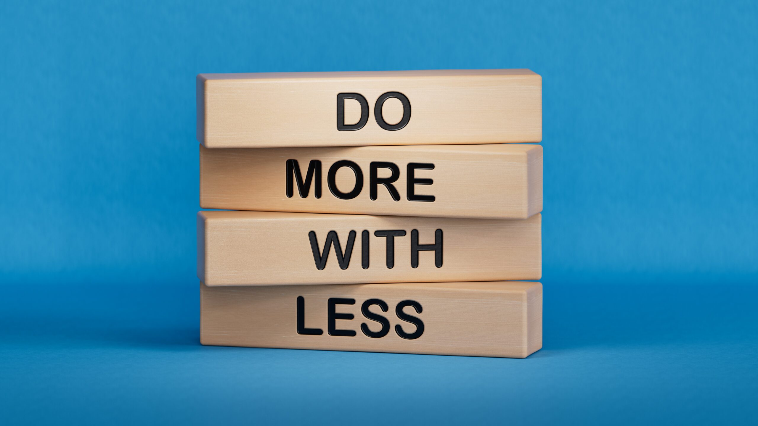 Explain it in 100 Words: Say Less, Engage More. Do more with less symbol. Concept words Do more with less on wooden blocks. Business and Do more with less concept. Copy space.3D rendering on blue background.