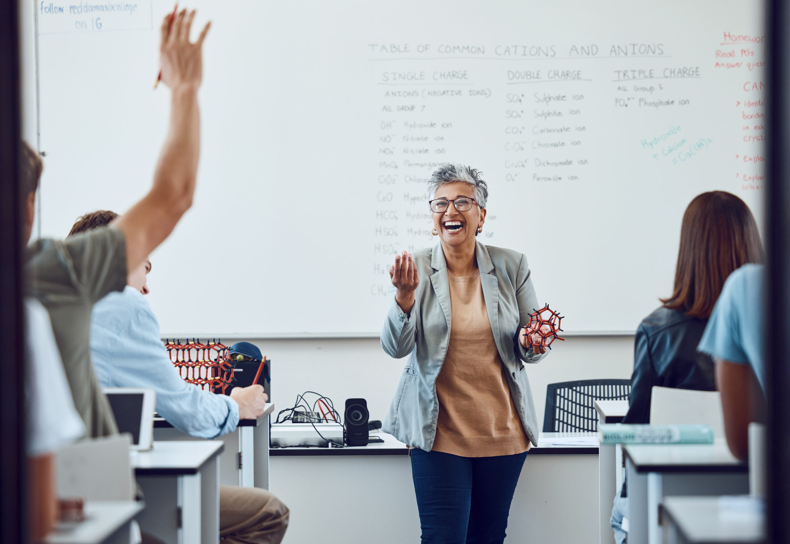 Classroom, teacher and at university or college with dna model in education, learning and teaching. Professor with students happy for development or knowledge trust