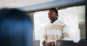 Black man, student and presentation with whiteboard for learning, moderation or education at university. African learner, assessment or introduction with notes or cue cards for oral exam at college